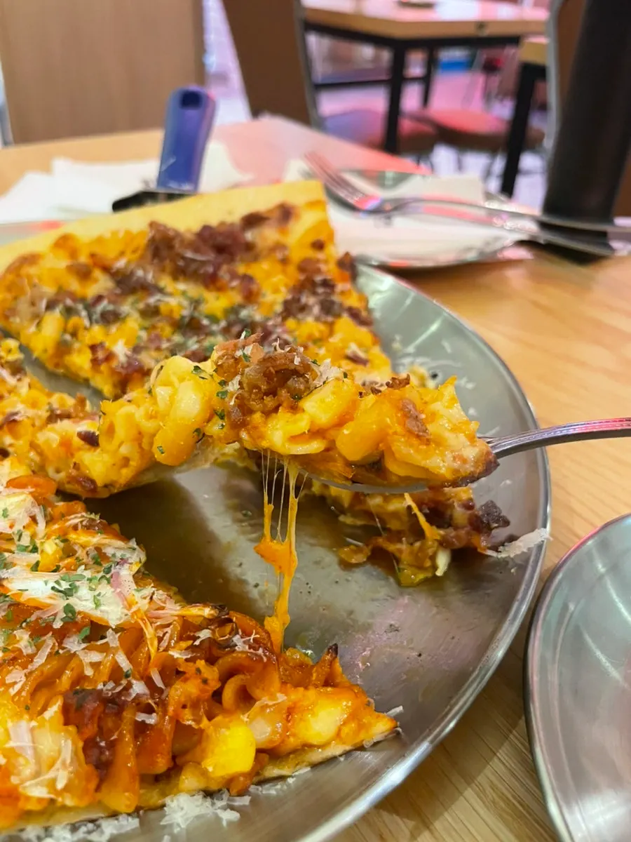 Mac and cheese pizza slice with stretchy cheese