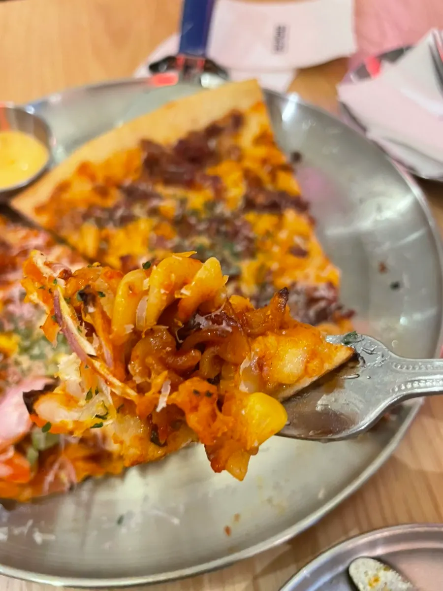 Cross-section of the mac and cheese pizza with macaroni