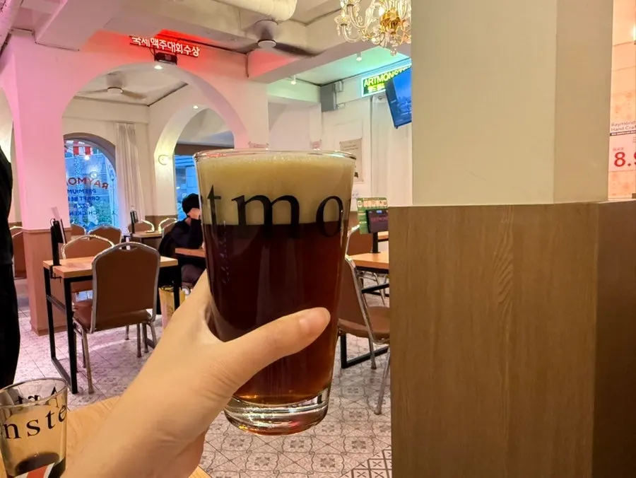 Holding a glass of pilsner lager