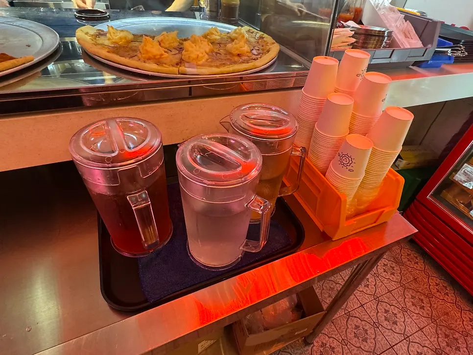 Slice pizzas displayed in front of the kitchen