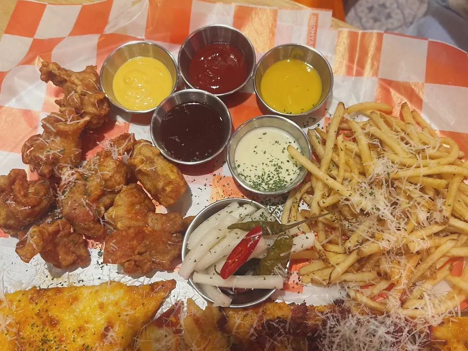 Pizza being dipped into cheese and garlic sauces