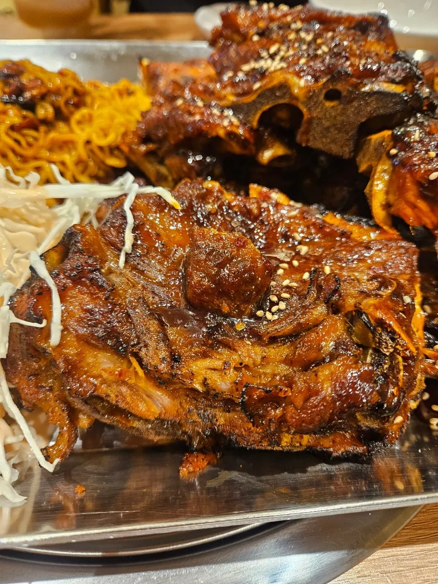 Grilled bones served with ramen noodles and seasoned cabbage