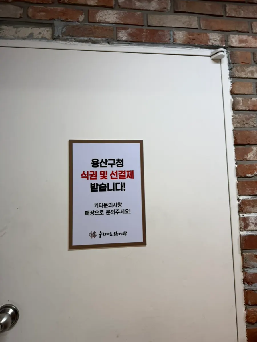 Sign noting acceptance of Yongsan-gu meal vouchers and prepayment