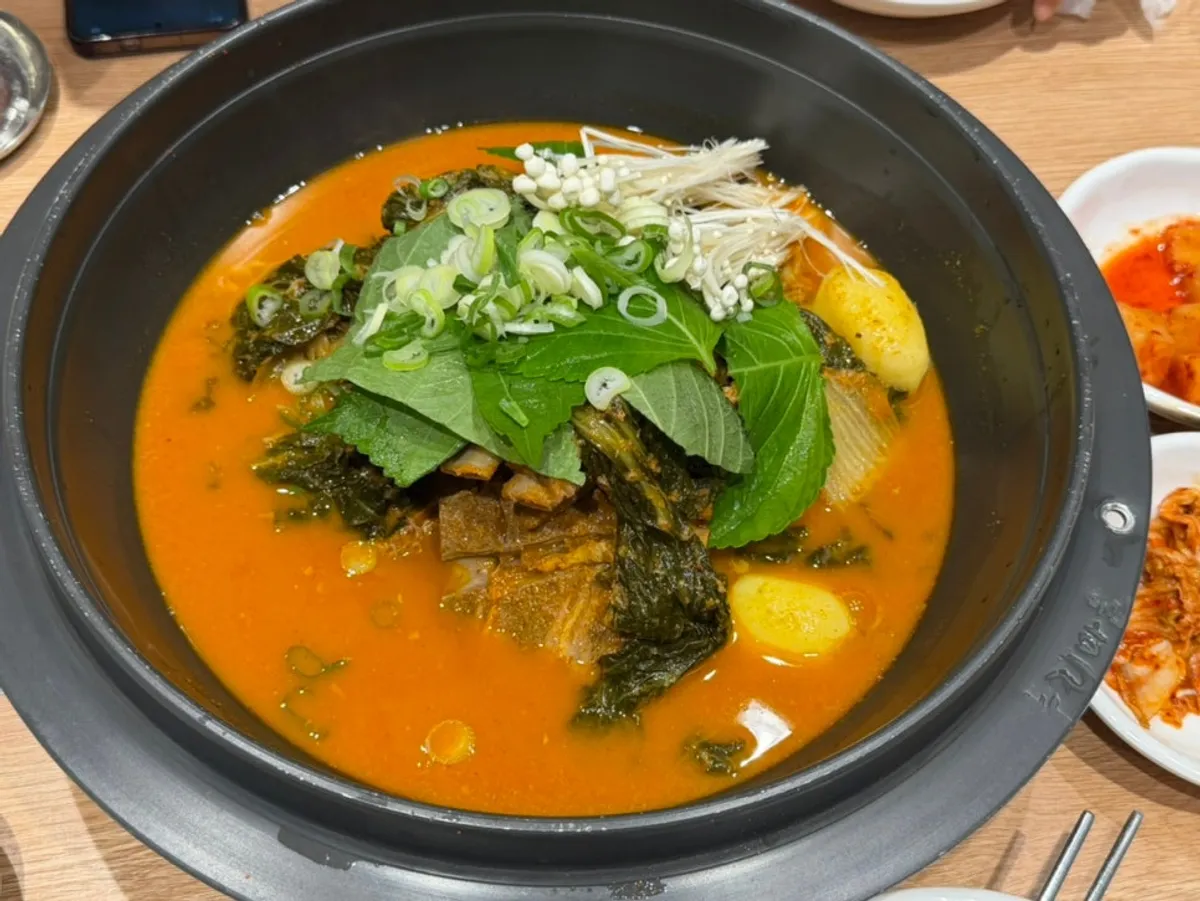 A full pot of Nuri Gamjatang loaded with radish greens