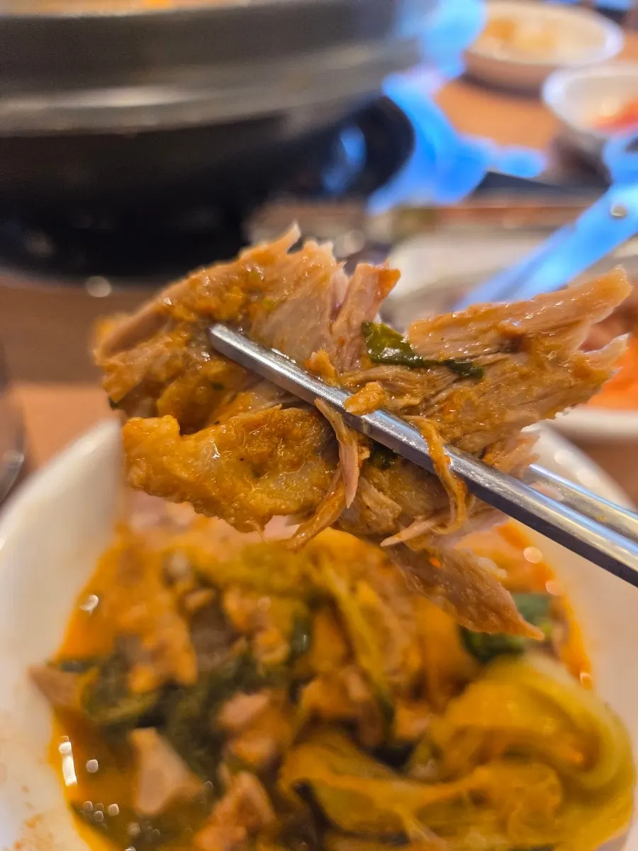 A chopstick of broth-soaked radish greens