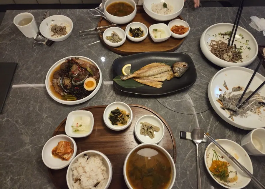 Main table spread with charcoal-grilled dried corvina and mixed seafood jang