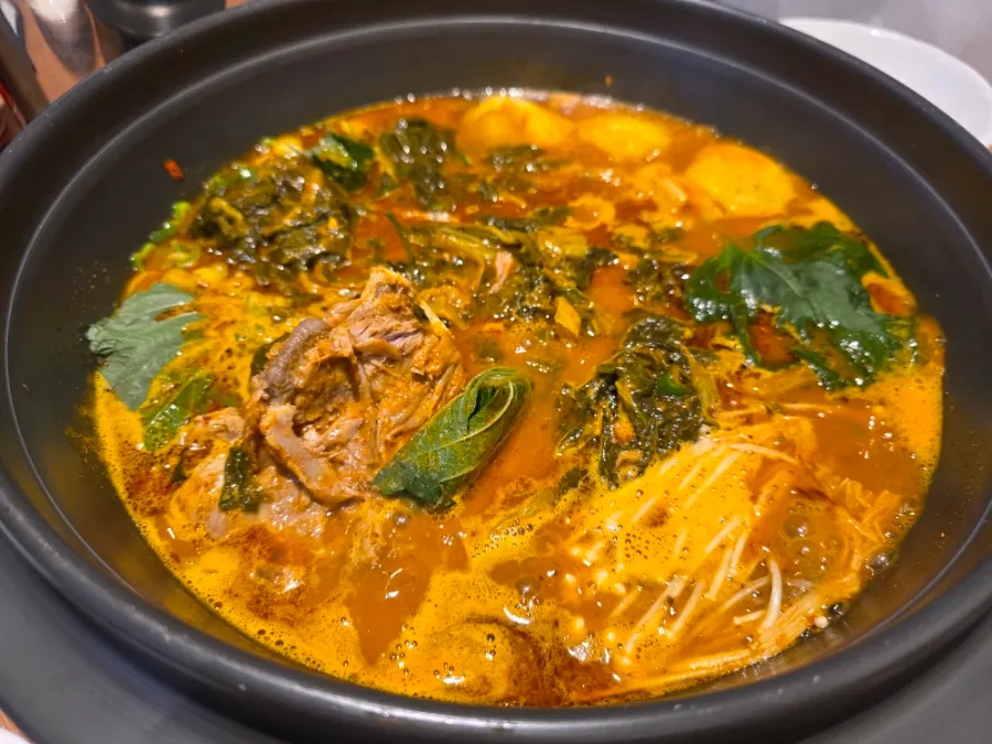 Pot of mala gamjatang with added potato sujebi and potato noodles