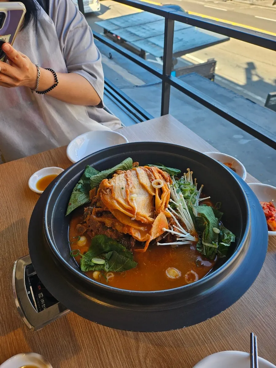 창가 테이블에 차려진 묵은지감자탕 한 상