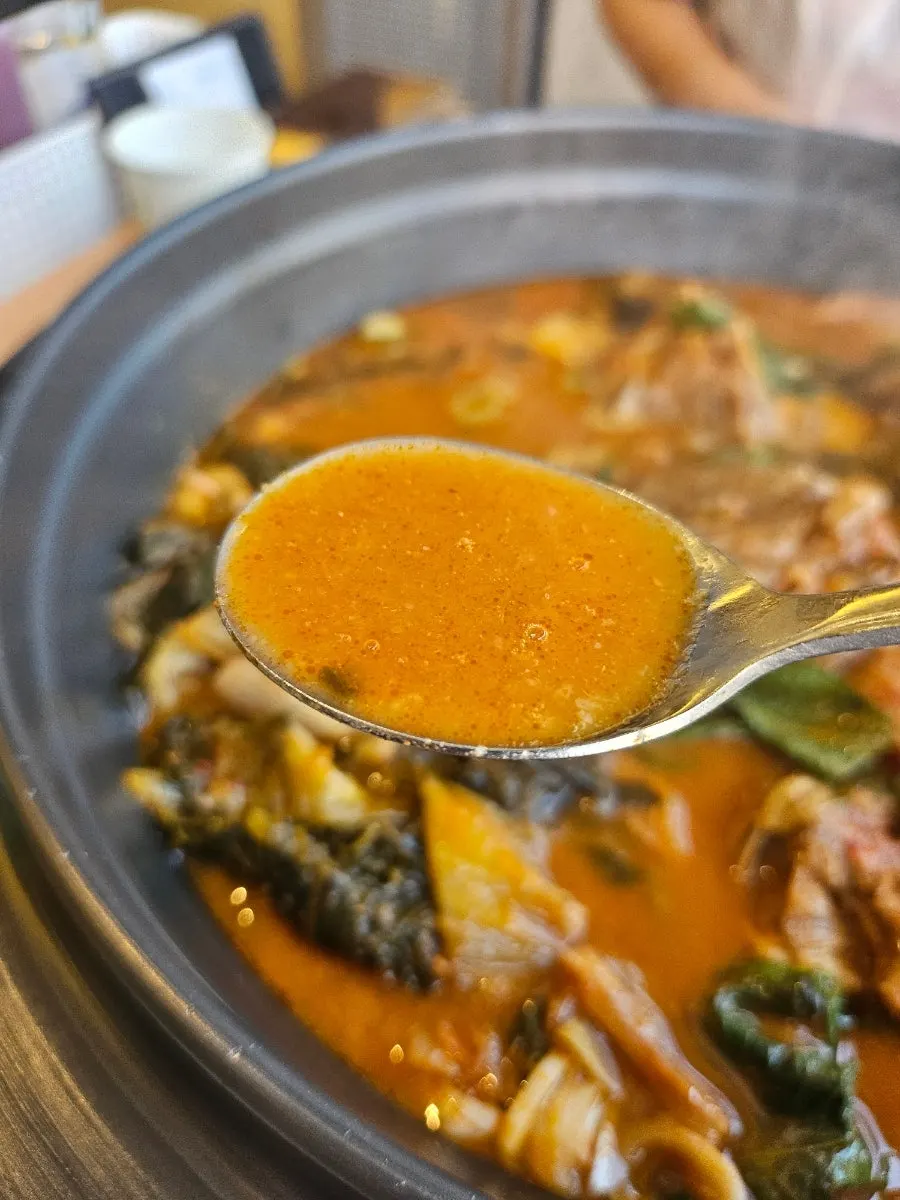 국자로 떠올린 진한 감자탕 국물