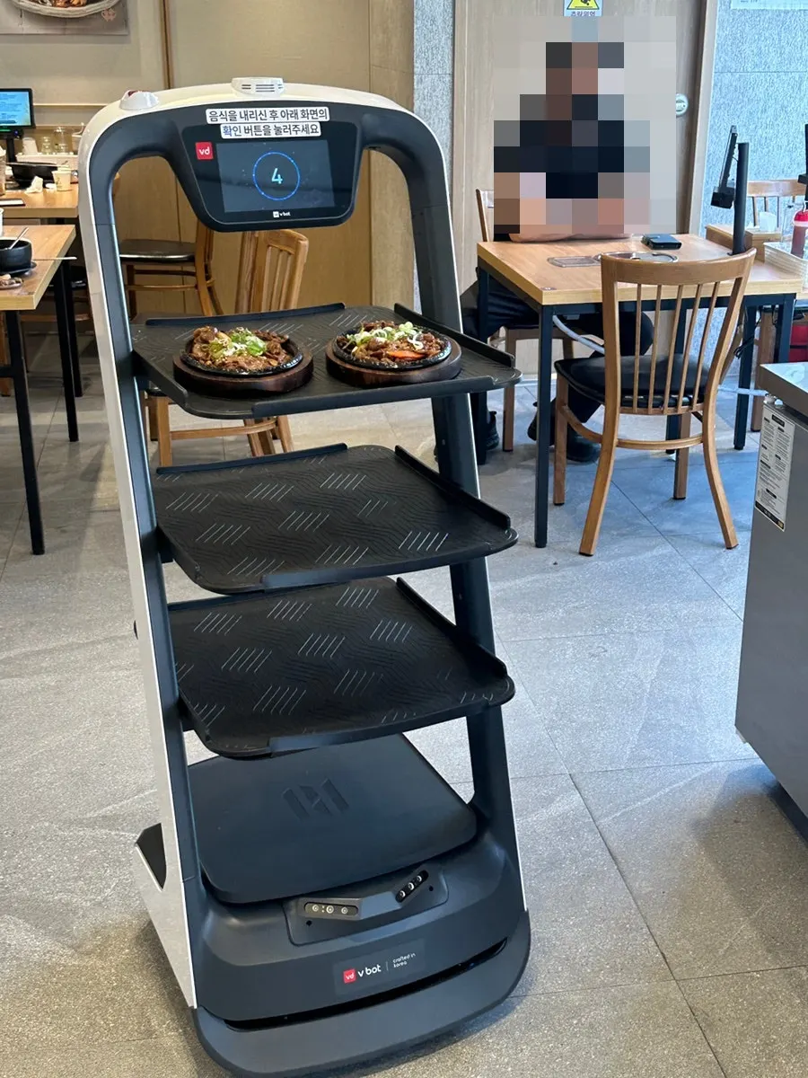 A serving robot moving through the restaurant