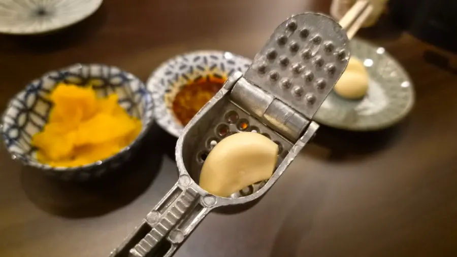 Raw garlic with a garlic crusher and danmuji side dish