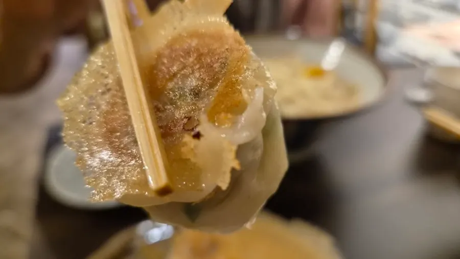 A plate of bite-size gyoza served alongside the ramen