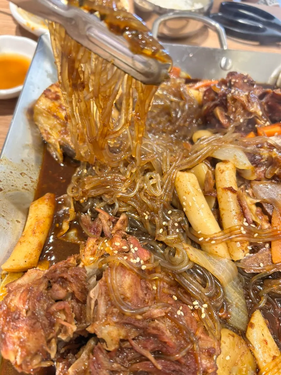 Close-up of spine bones, glass noodles and rice cake in the soy-braised bone stew