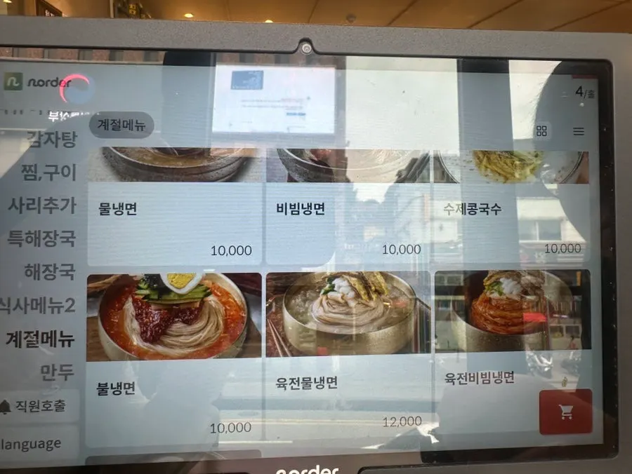 Side menu board listing pork dumplings and kimchi dumplings