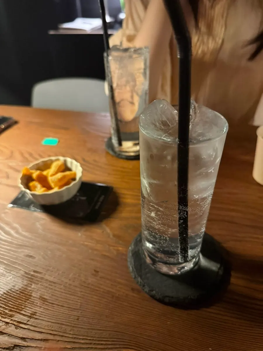 Peach highball glass under the bar lighting