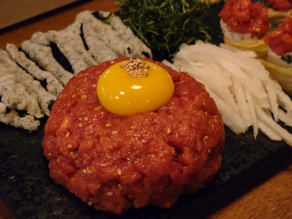 Yukhoe tossed in seasoning with pear on the side