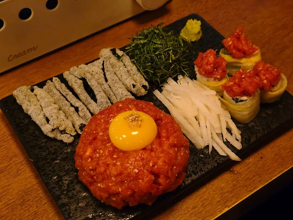 A bite of yukhoe with kim-bugak and wasabi