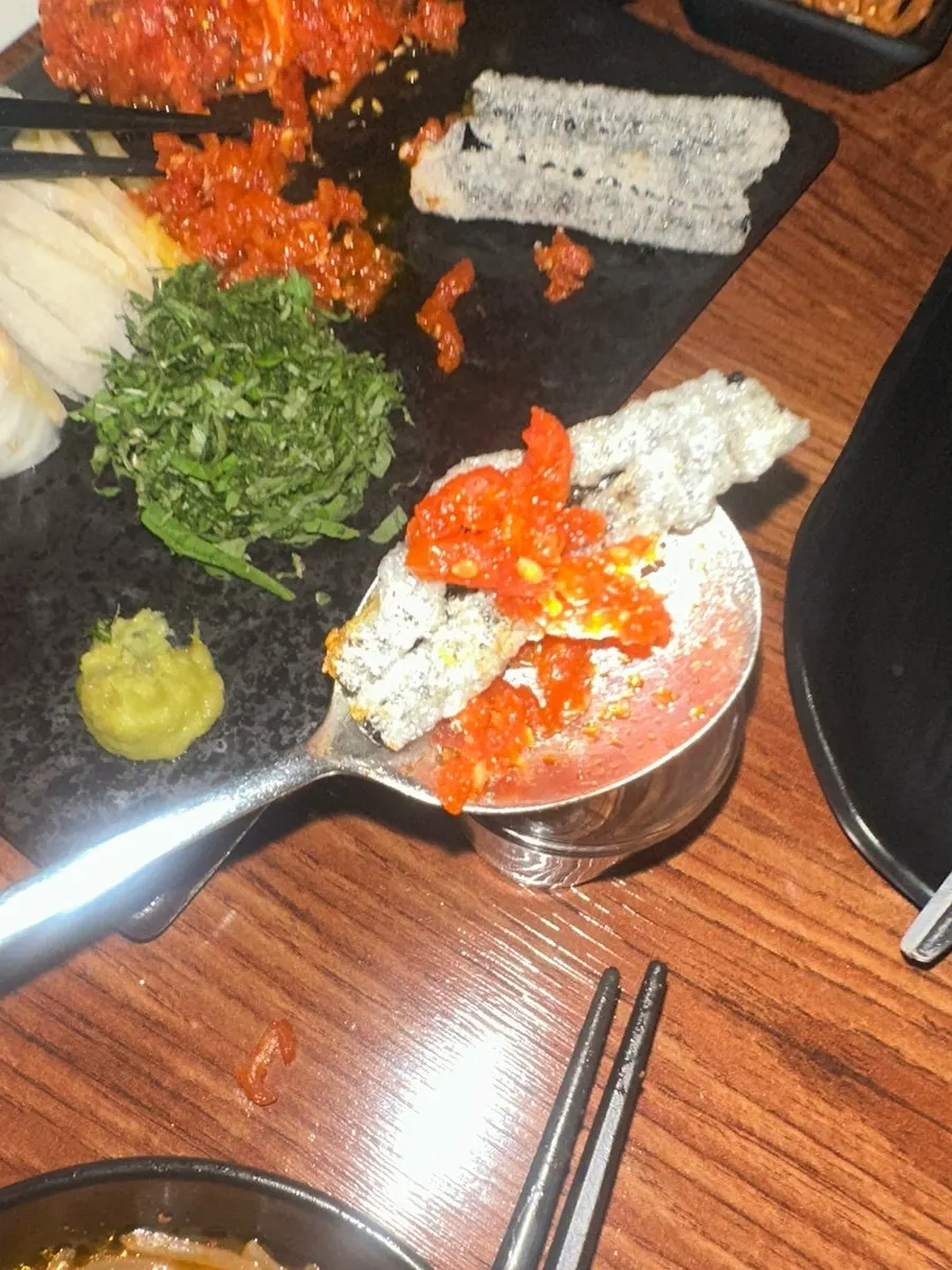 Red yukhoe eaten with a gim-bugak chip