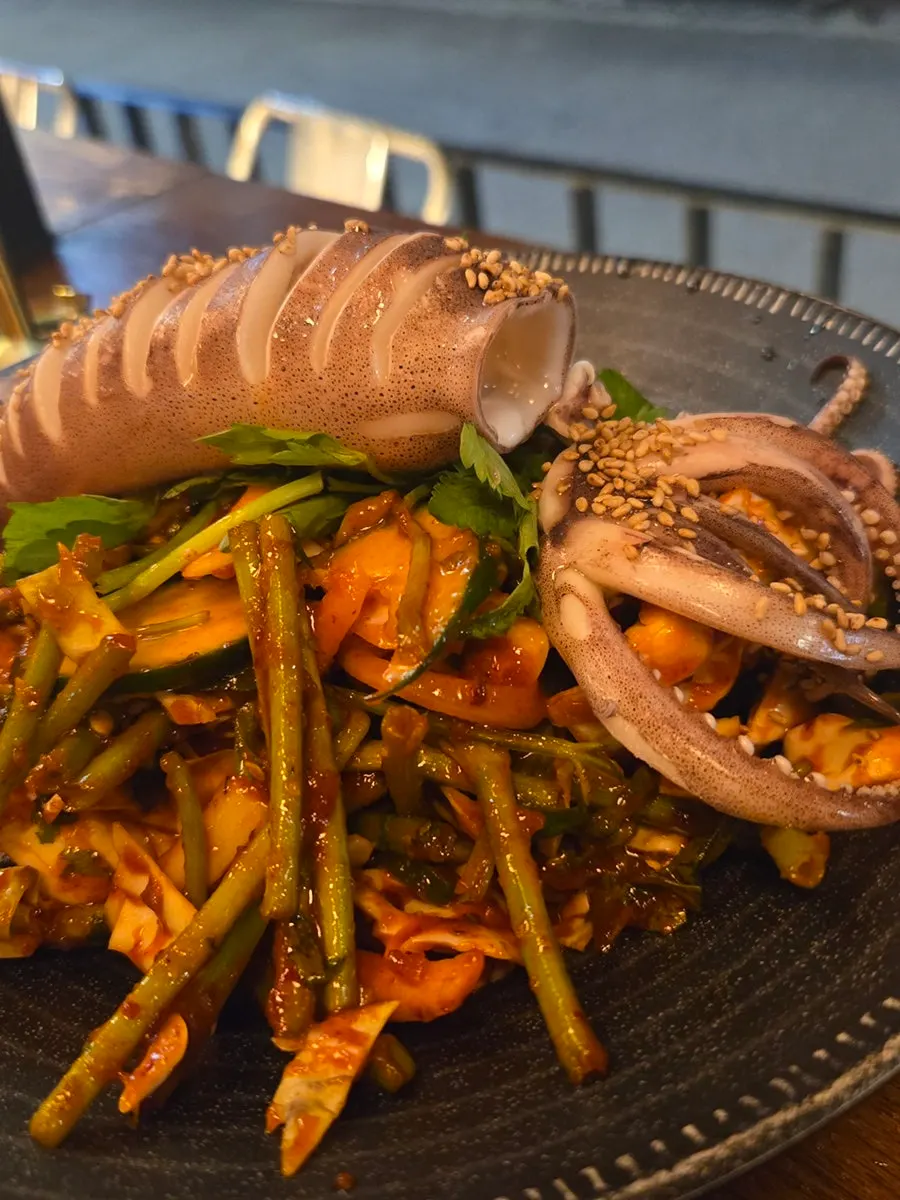 묵은지 참치말이 한 점을 집은 모습