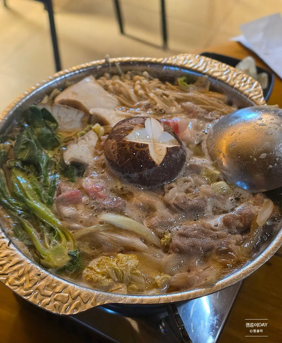 A pot of sukiyaki loaded with vegetables and meat