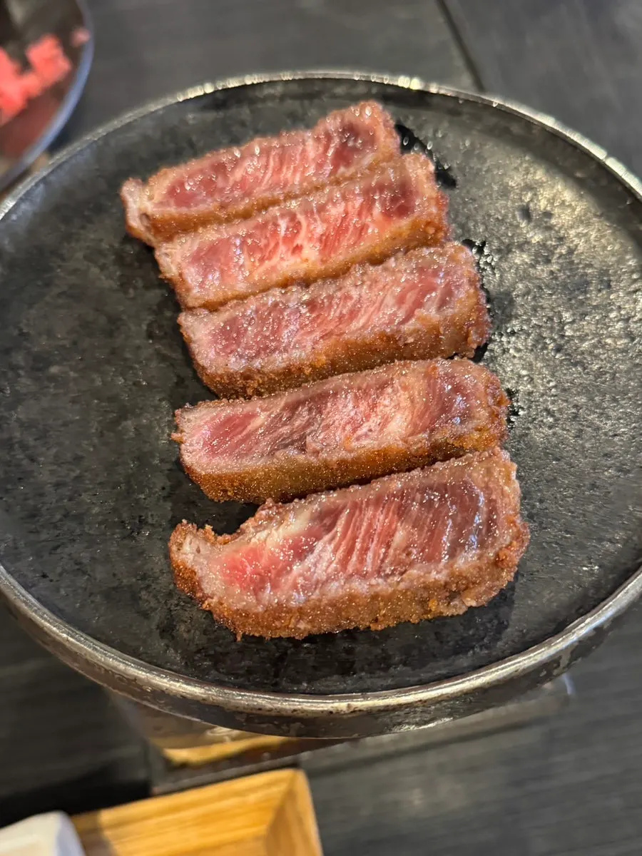 A piece of gyukatsu grilling on the mini brazier
