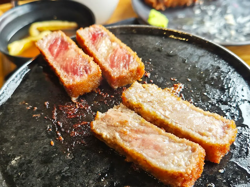 A piece of gyukatsu being grilled on the brazier