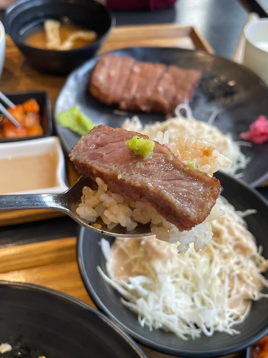 Meat topped with wasabi alongside rice