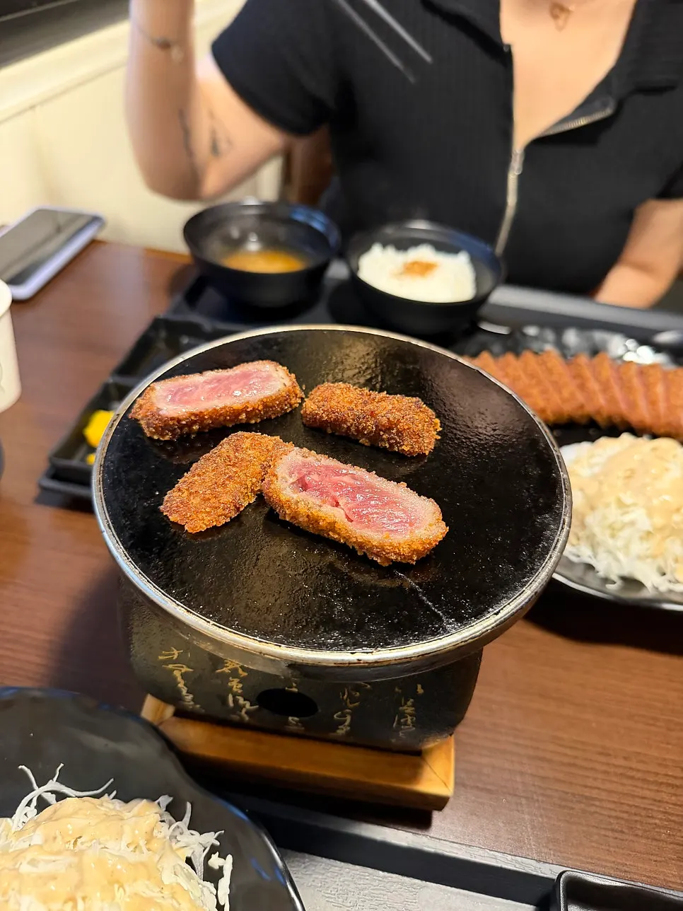 Beberapa keping gyukatsu digoreng di atas dapur mini