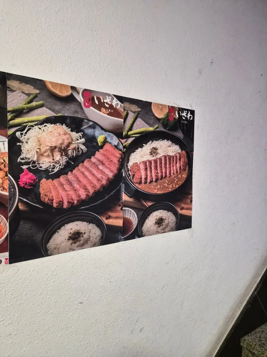 계단에 붙은 규카츠의 원조 이자와 포스터