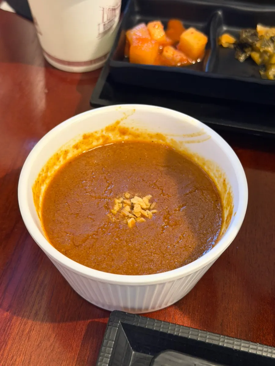 마늘 슬라이스가 올라간 맛보기 카레