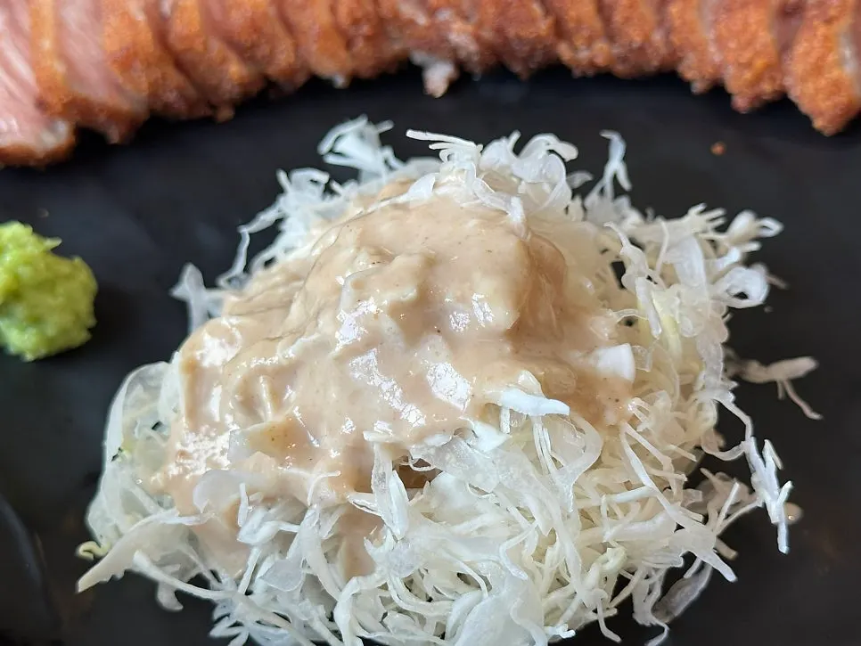 Shredded cabbage salad topped with sauce