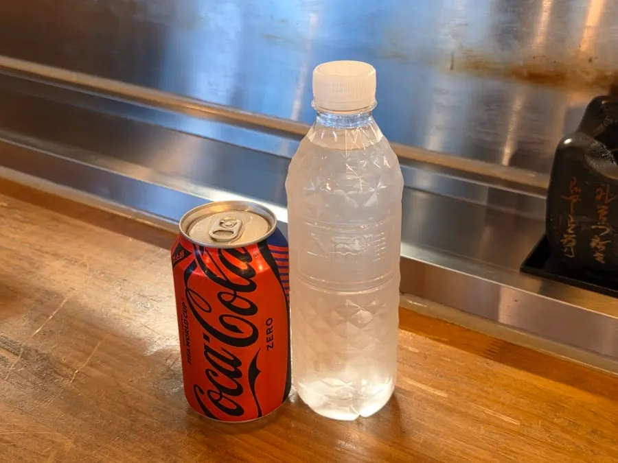 Izawa's personal mini grill with zero-sugar cola and individual bottled water