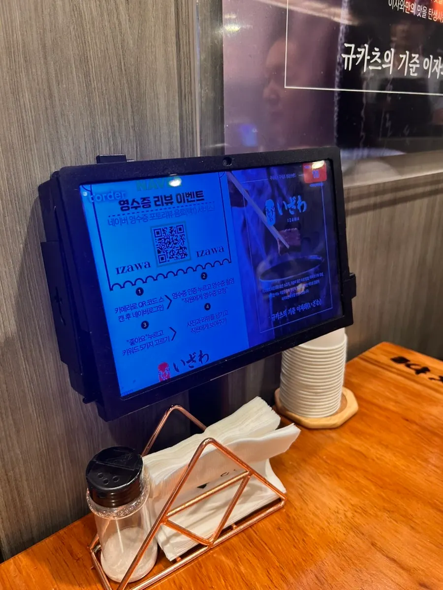 Two tables pushed together for a group of 4, with the kiosk visible
