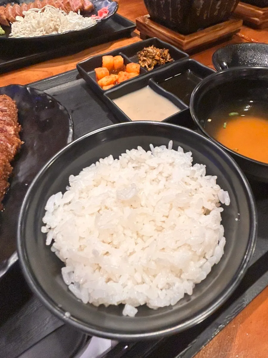 Side dishes, sauces, rice, and soup served with the gyukatsu set