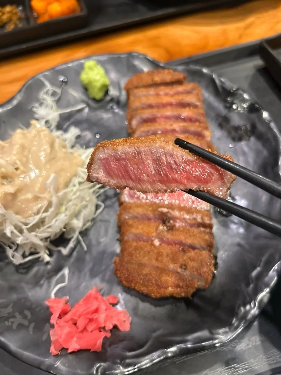Gyukatsu piece placed on the grill before cooking