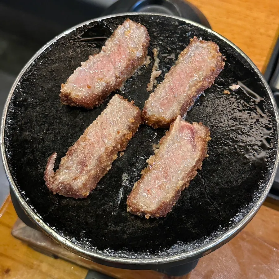 A piece of gyukatsu dipped in sauce