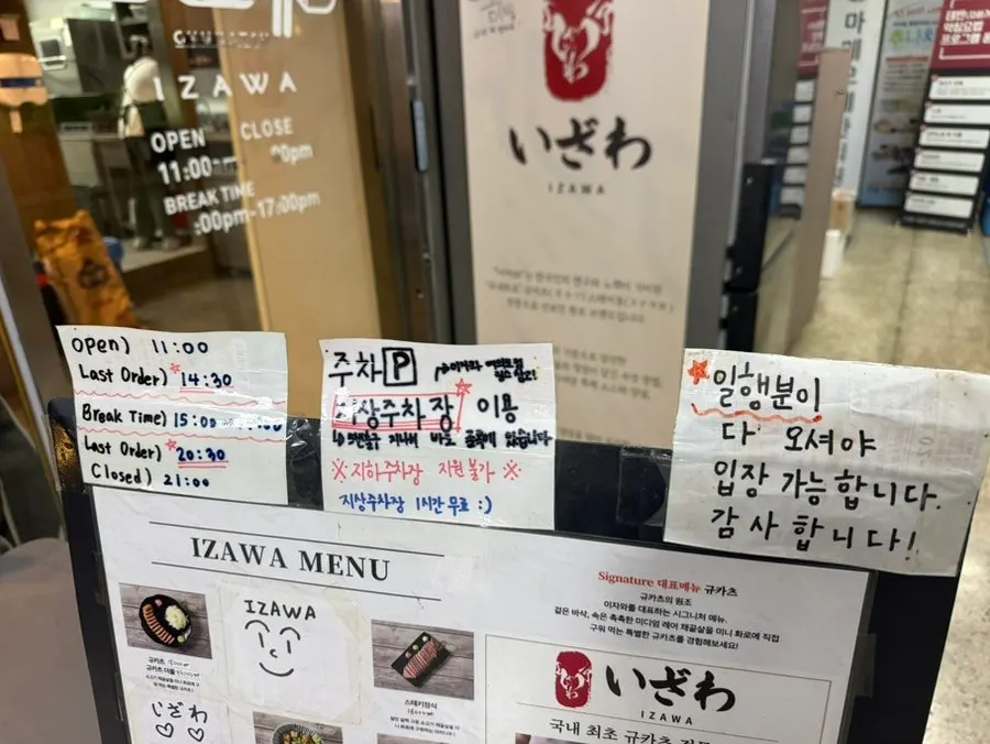 영업시간과 주차 안내가 붙은 이자와 여의도직영점 입구