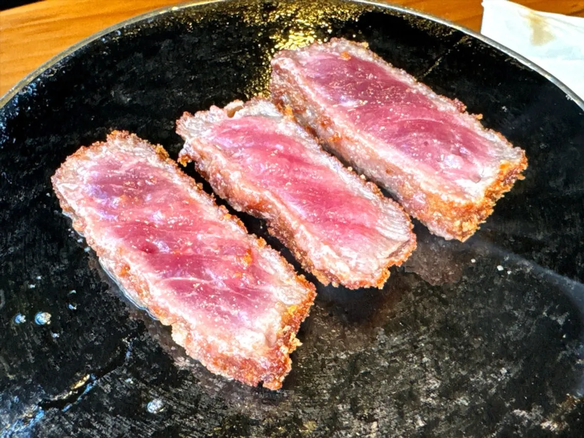 Picking up a piece of gyukatsu with a reddish center