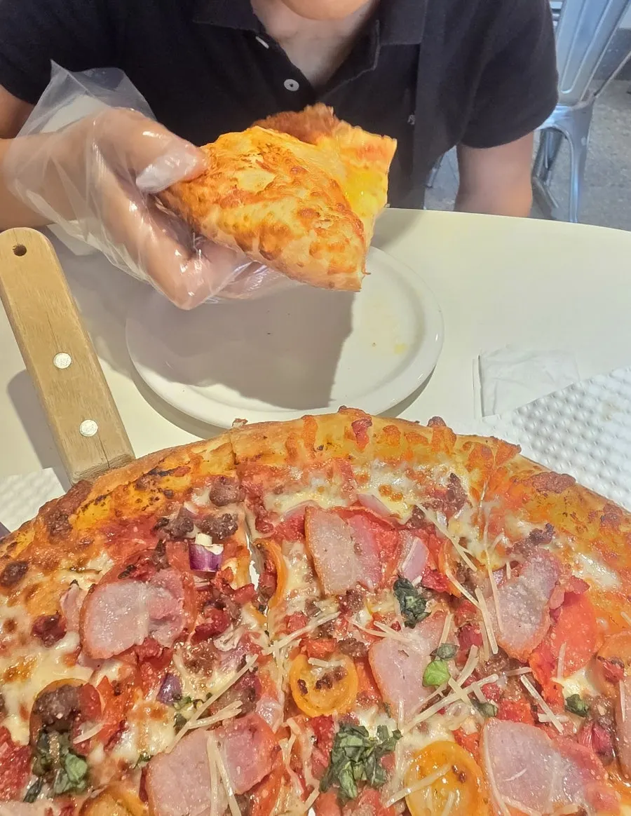 Eating pizza with disposable gloves on