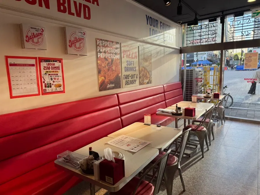 Seating area at Jackson Pizza Wirye Branch with large lettered signage