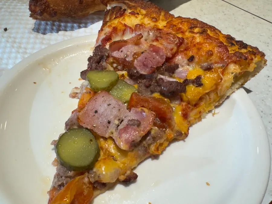 Melting Cheeseburger pizza topped with beef and pickles