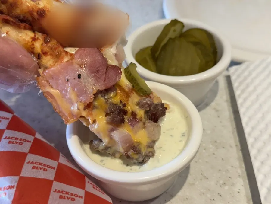 Dipping a pizza slice into ranch sauce
