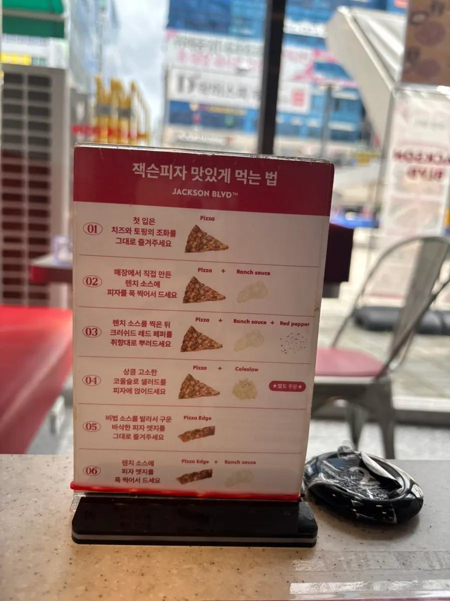 Sign showing how to best enjoy Jackson Pizza