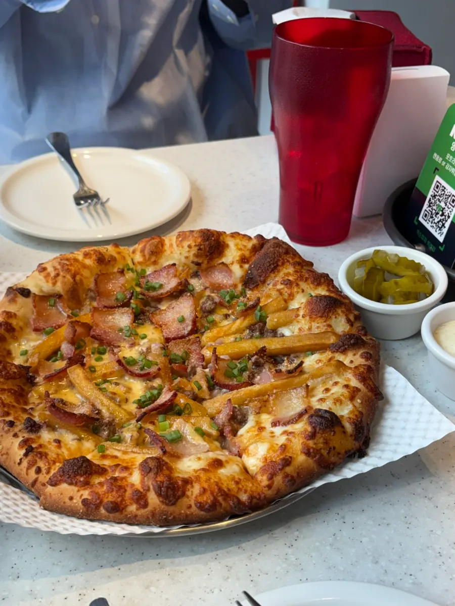 Zesty Jackson pizza topped with thick fries and bacon