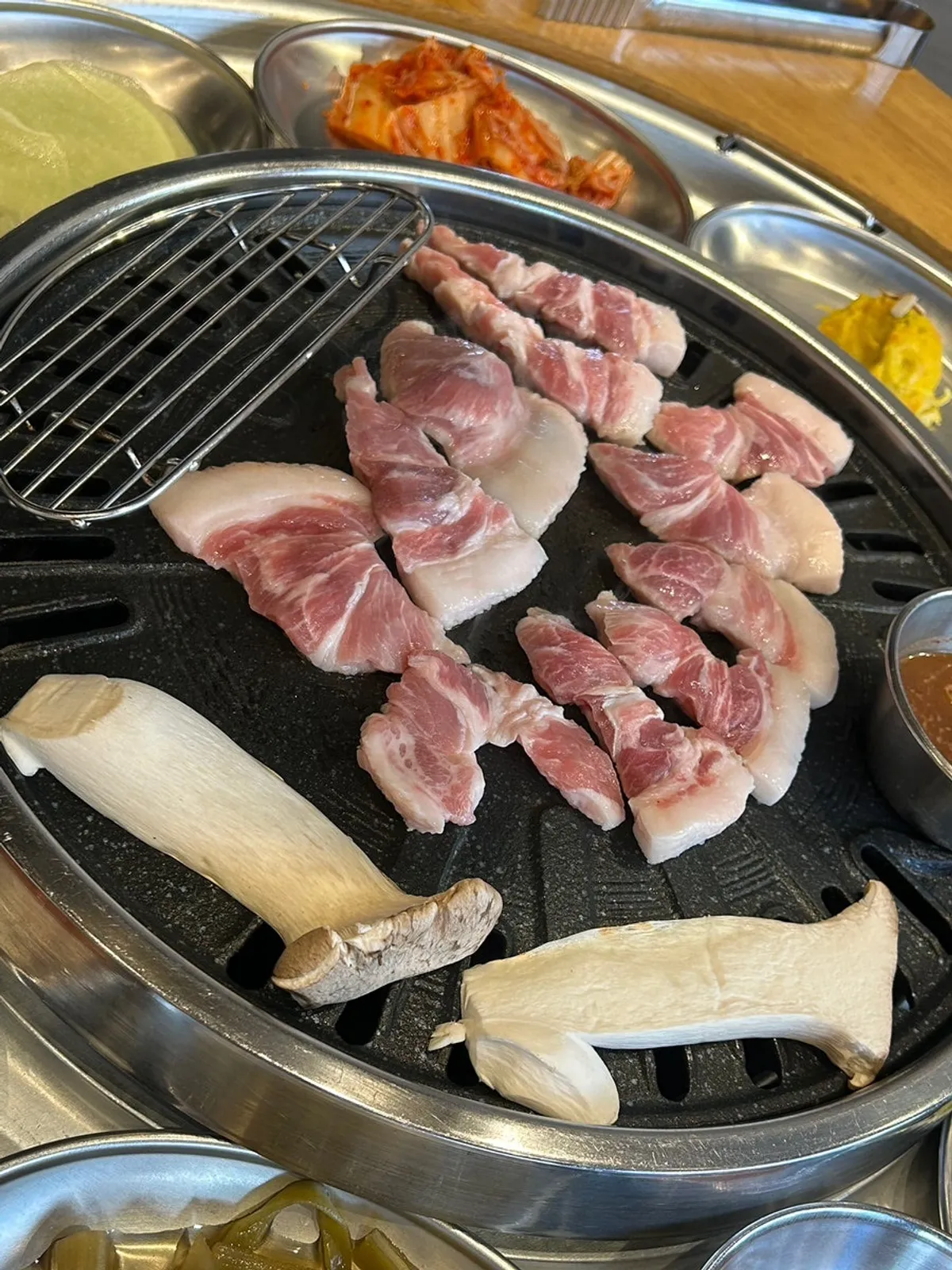 Kkodeulsal grilling alongside mushrooms