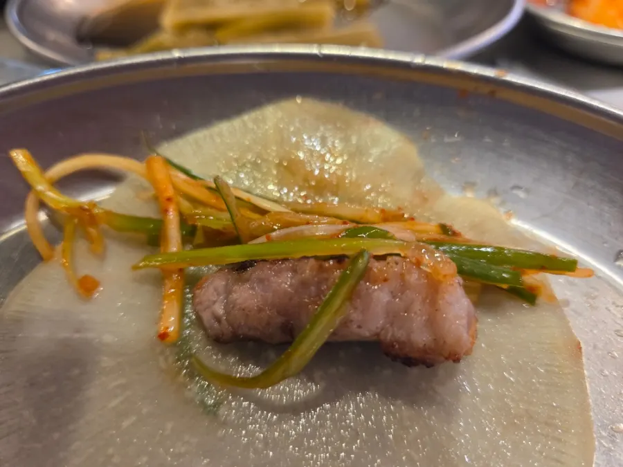 Meat wrapped with scallion shreds and pickled radish
