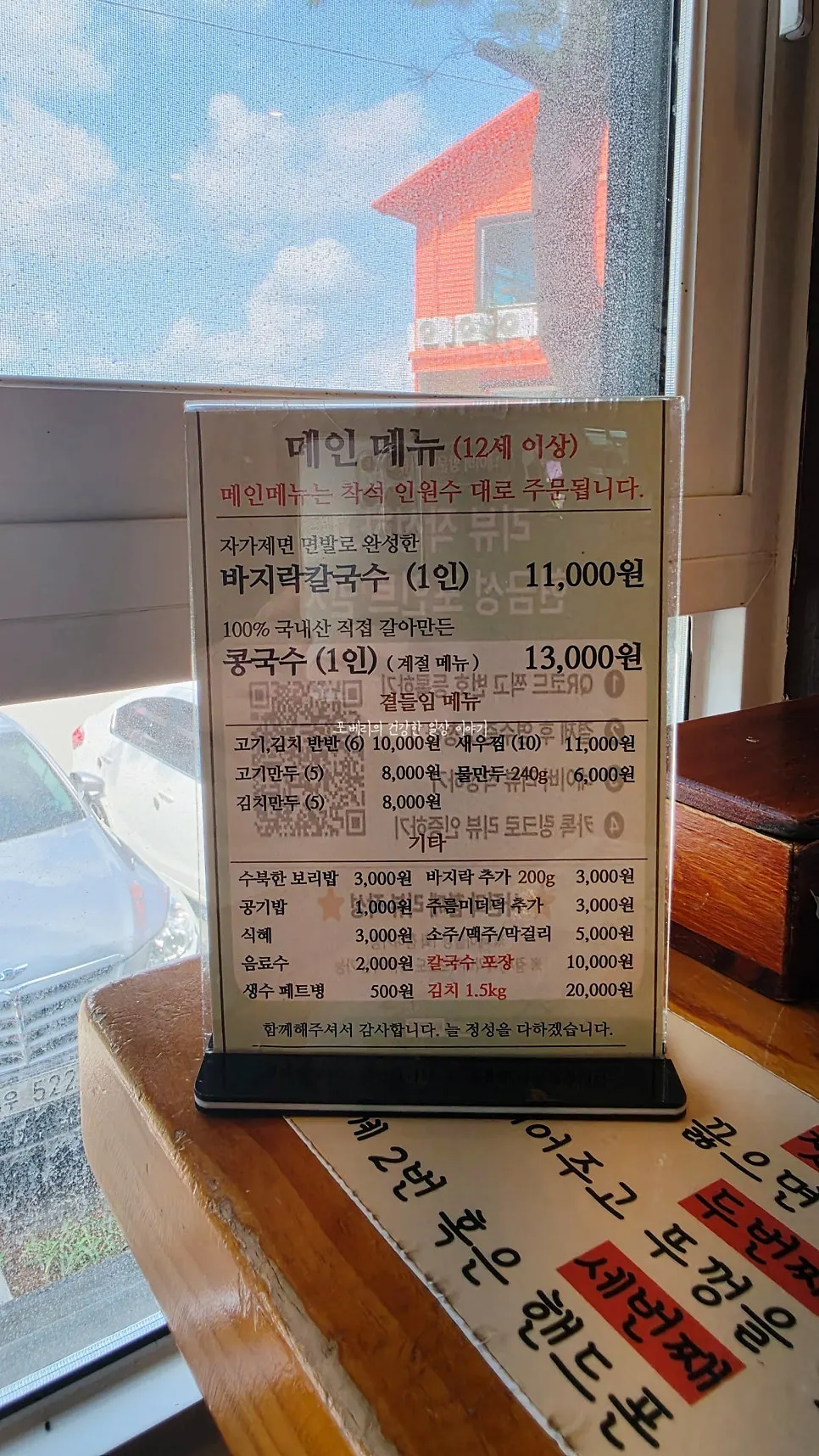 Menu board listing clam kalguksu and dumplings