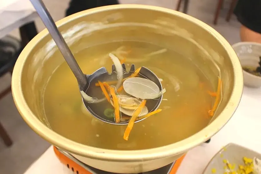 Chewy corn noodles lifted out of the bowl