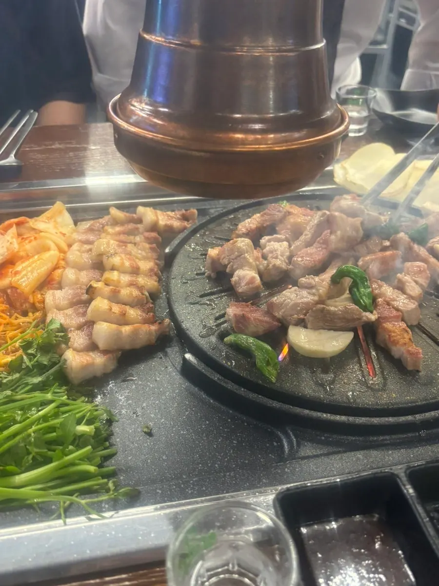 Sepotong daging siap dan hidangan lengkap di meja