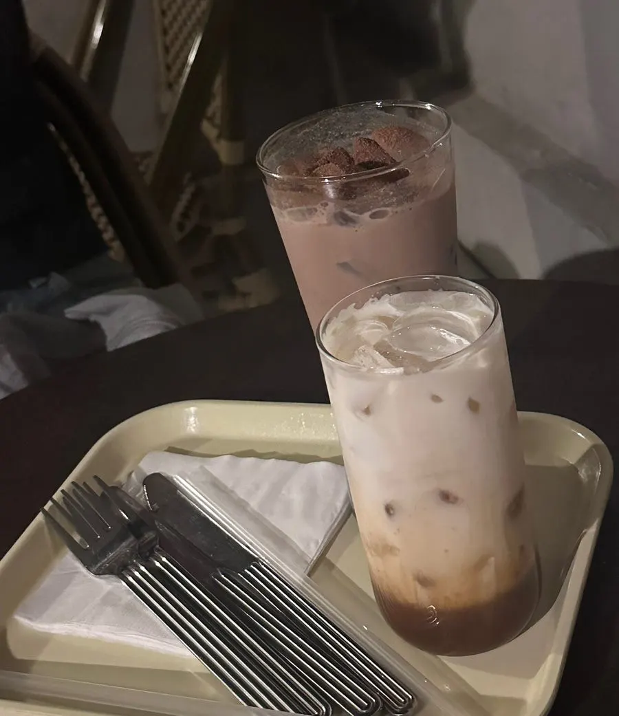 Iced vanilla latte and iced chocolate milk on an outdoor table
